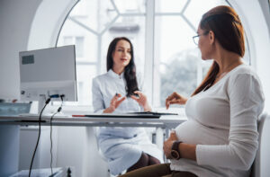 Mujer embarazada en consulta ginecológica hablando sobre cultivos vaginales