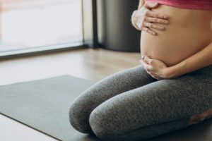 mujer embarazada ejercitandose clase pilates min