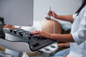Mujer embarazada en consulta ginecológica revisando los niveles de ácido fólico y embarazo