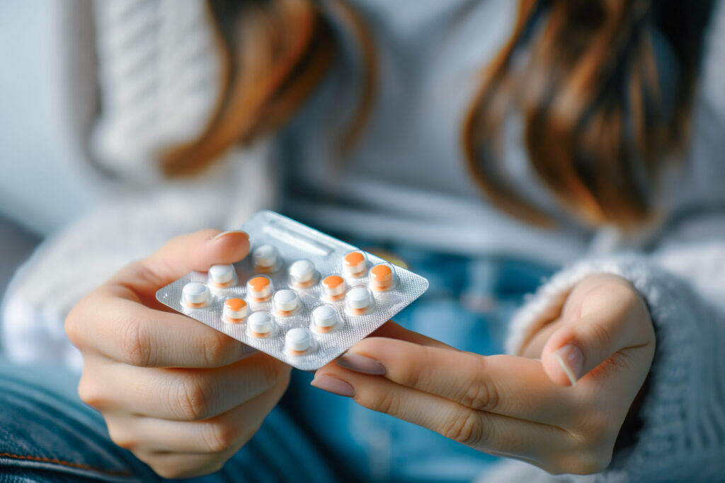 Close Up of Female Hands Holding Dual Colored Pills