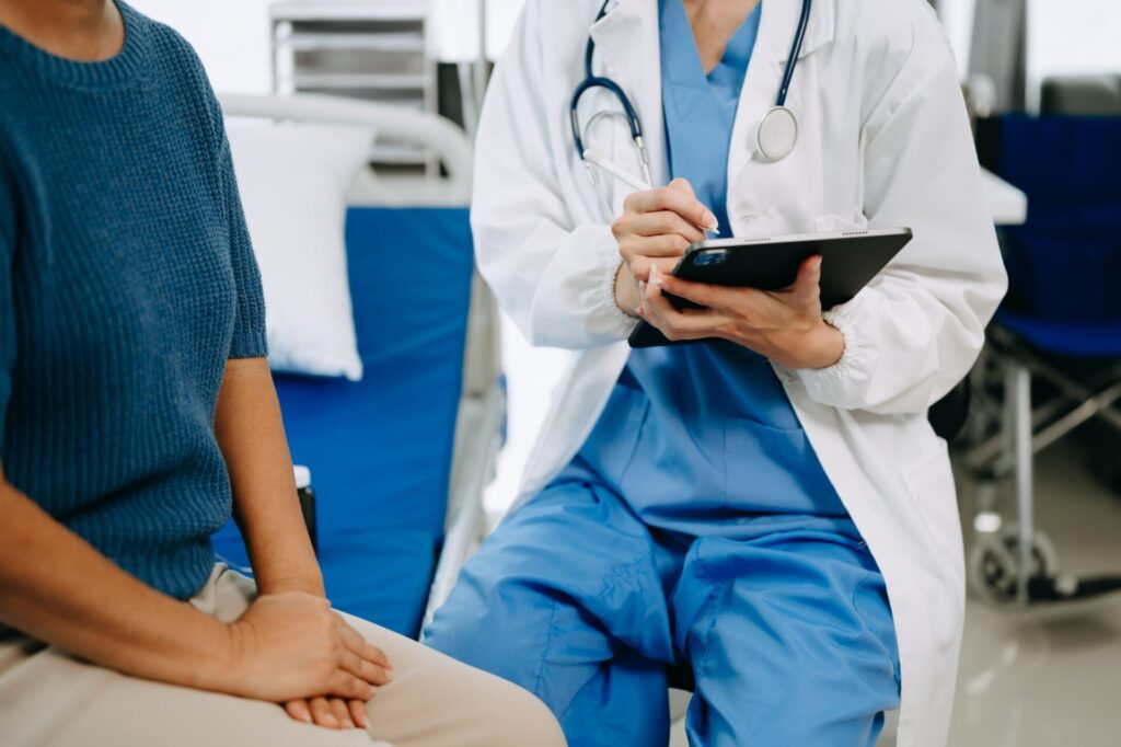 doctor senior female patient who lie bed while checking pulse consult explain with nurse taking note hospital wards clinicxa (1) min