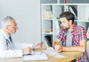 Hombre hablando con su médico sobre astonozoospermia