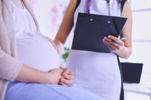 Doctora con paciente embarazada viendo los resultados de las pruebas para ver si tiene un hematoma en el embarazo