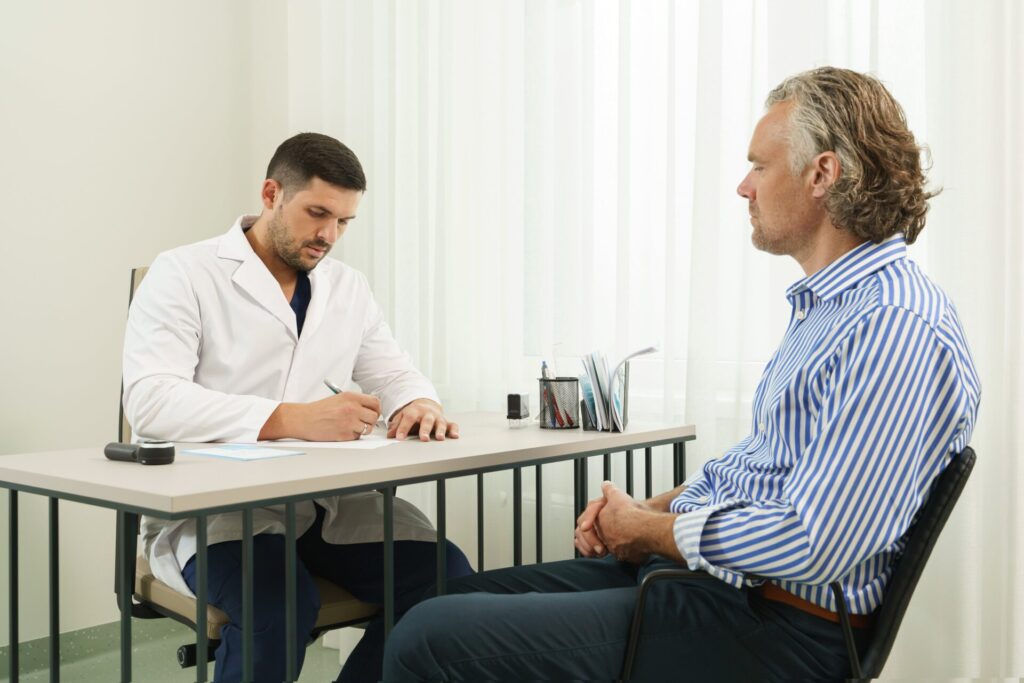 doctor middle aged male patient consultation office min