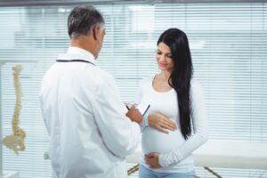 mujer embarazada interactuando medico para saber si es más fácil quedarse embarazada después de una FIV