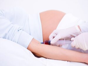 medico toma sangre analisis mujer embarazada para realizar el triple screening
