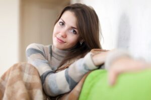 Mujer en el sofá recuperandose de las consecuencias de quitar el útero por miomas
