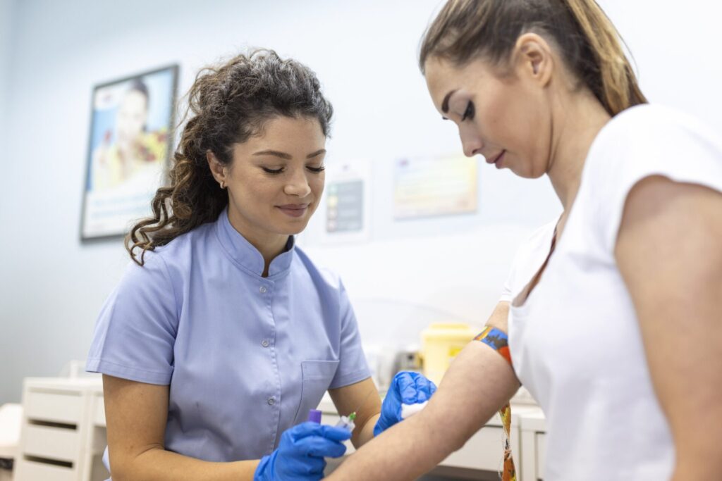tecnologo medico que realiza servicios de extraccion de sangre para el asistente de laboratorio del paciente con guantes de goma esteriles que toman muestras de sangre del paciente min